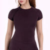 A dark plum performance fitness short sleeve top for women shown on a model.