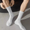 Une paire de chaussettes en tube tricotées blanches portées sur la jambe d'une personne.
