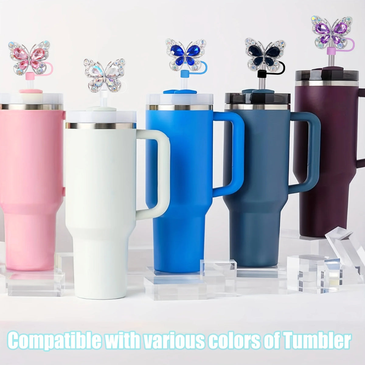 Un set de quatre toppers à paille en silicone en forme de papillon, dans différentes couleurs comme le rose, le blanc, le ble