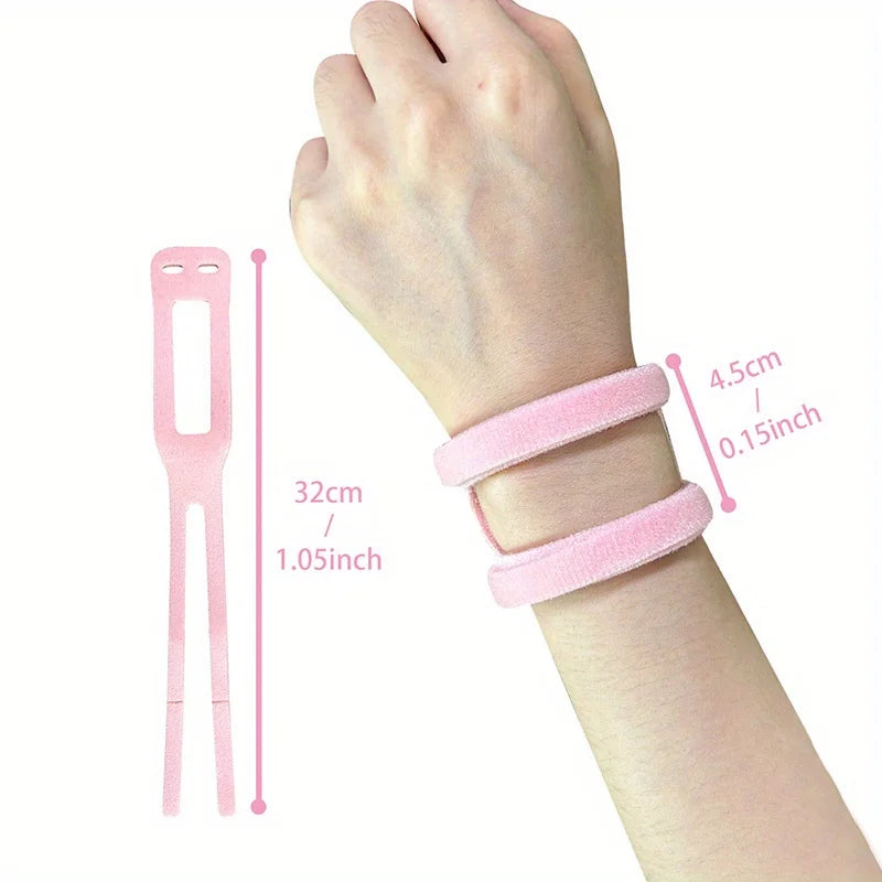 A hand wearing a pink elastic pressure wrist strap for carpal tunnel relief, showing the strap size and application.