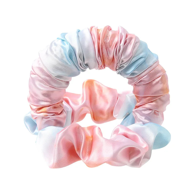 A headband made of pink and blue satin fabric with gathered folds.