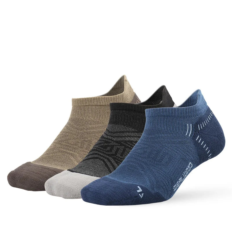 A collection of five breathable performance running socks in various shades of gray and blue laid out flat.