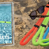 A collection of floating eyewear straps in orange, green, blue, and black are displayed on sand.