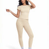 Modelo vistiendo un conjunto de yoga sin costuras beige de cintura alta, con top de manga corta y pantalones ajustados.