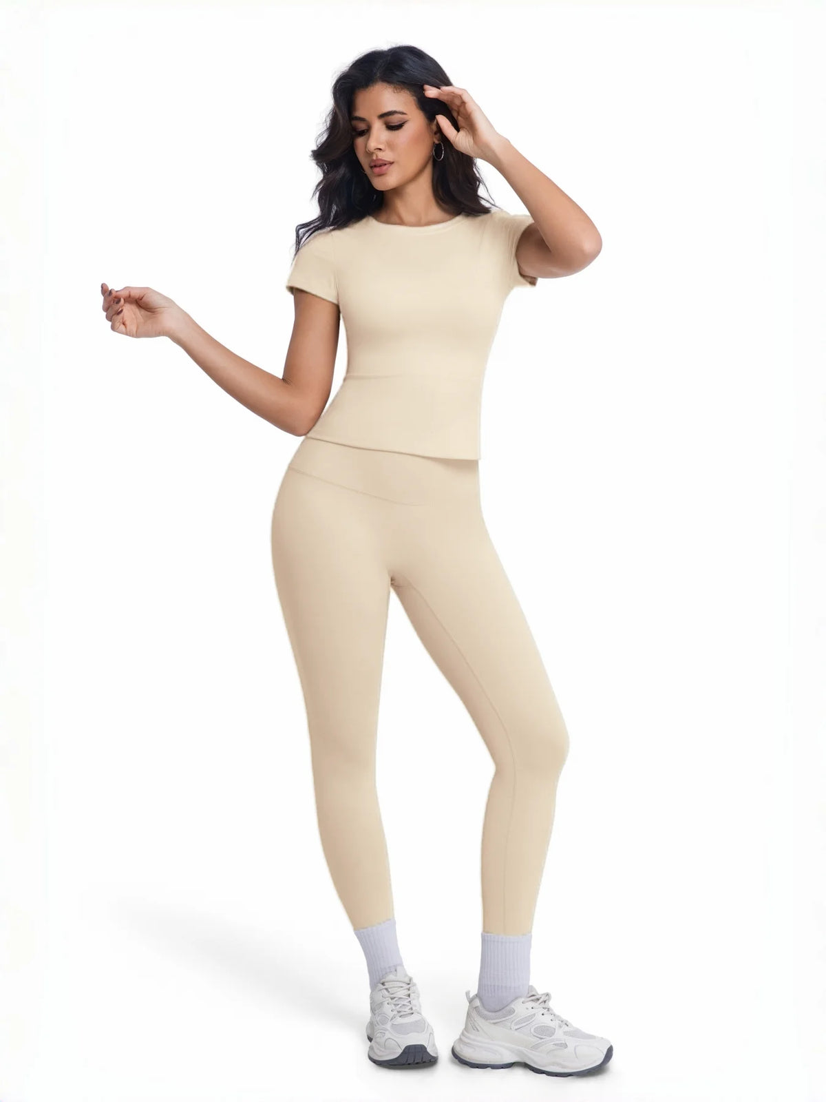 Modelo vistiendo un conjunto de yoga sin costuras beige de tiro alto, con top de manga corta y pantalones ajustados.