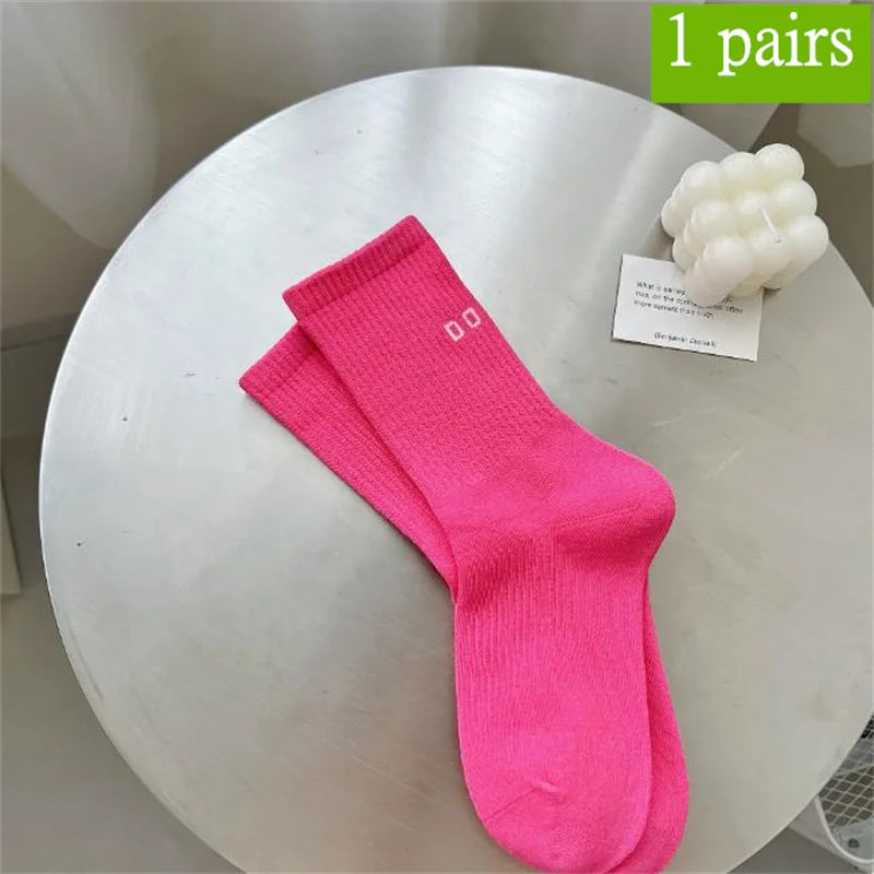 Ein Paar leuchtend pinker, atmungsaktiver, rutschfester Yoga- und Fitnesssocken auf einem weißen Tisch.