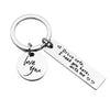A silver metal keychain with a circular ring attached and a rectangular tag engraved with the words I love you Drive safe I n