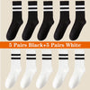 A collection of ten pairs of black and five pairs of white breathable cotton sport socks displayed in a flat lay.