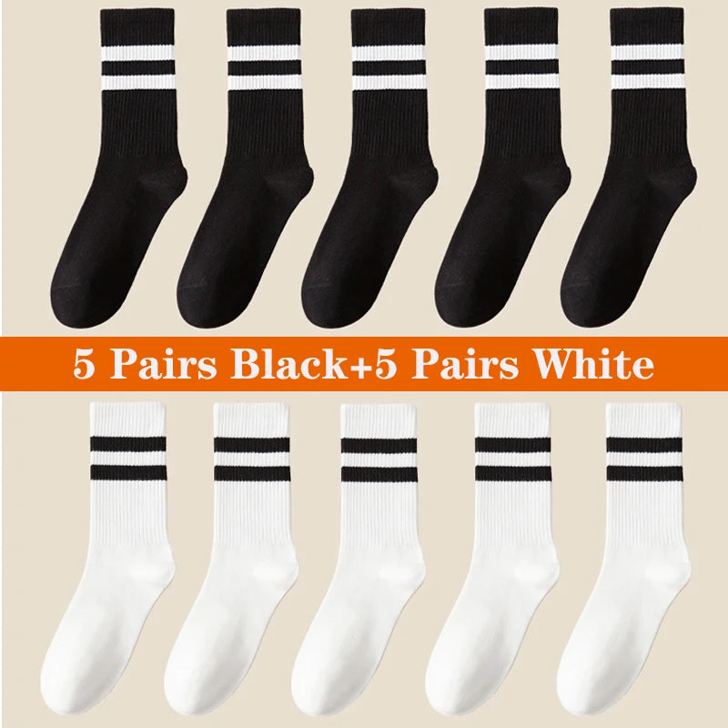 A collection of ten pairs of black and five pairs of white breathable cotton sport socks displayed in a flat lay.