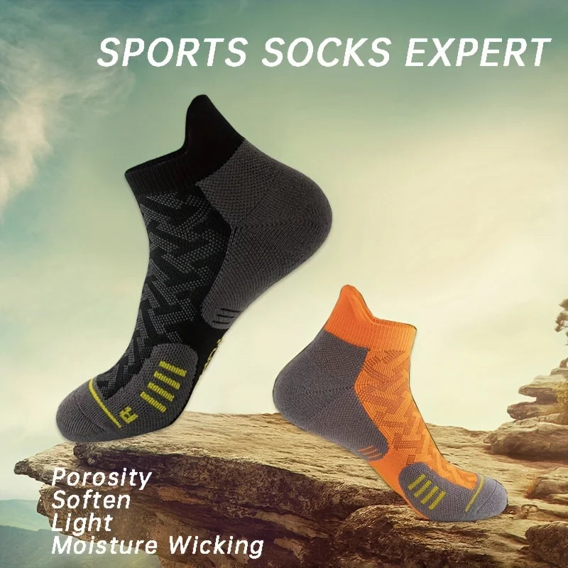 A pair of gray and orange sports socks resting on a rock, highlighting porosity, softness, light weight, and moisture-wicking