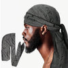 A man wearing a distressed pirate style durag head wrap with a beard, shown in profile.