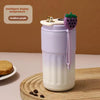 A purple thermo mug with an intelligent display showing a gradient purple color and a strawberry lid sits on a wooden surface