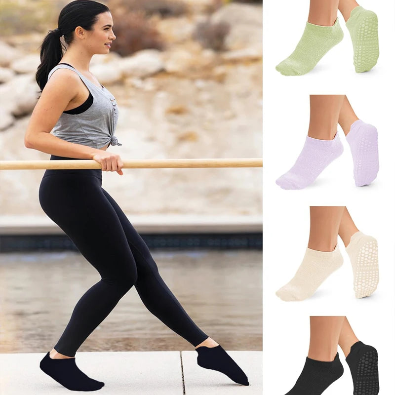 A woman wearing black yoga pants and black socks is leaning on a wooden bar, with various colored non-slip yoga socks display