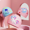 Pink and blue silicone swimming caps featuring cartoon unicorns and space themes displayed on a pink wall.