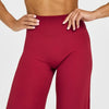 A model wearing high-waist yoga pants in a deep red color.