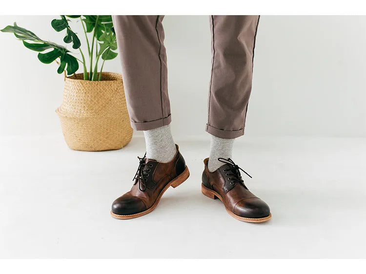 Une paire de bottes en cuir marron avec des chaussettes grises et un pantalon vert olive.
