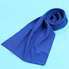 A royal blue microfiber cooling towel is rolled and laid on a light blue surface.