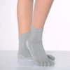 Gray yoga socks worn on a foot, showing the texture and dotted pattern.