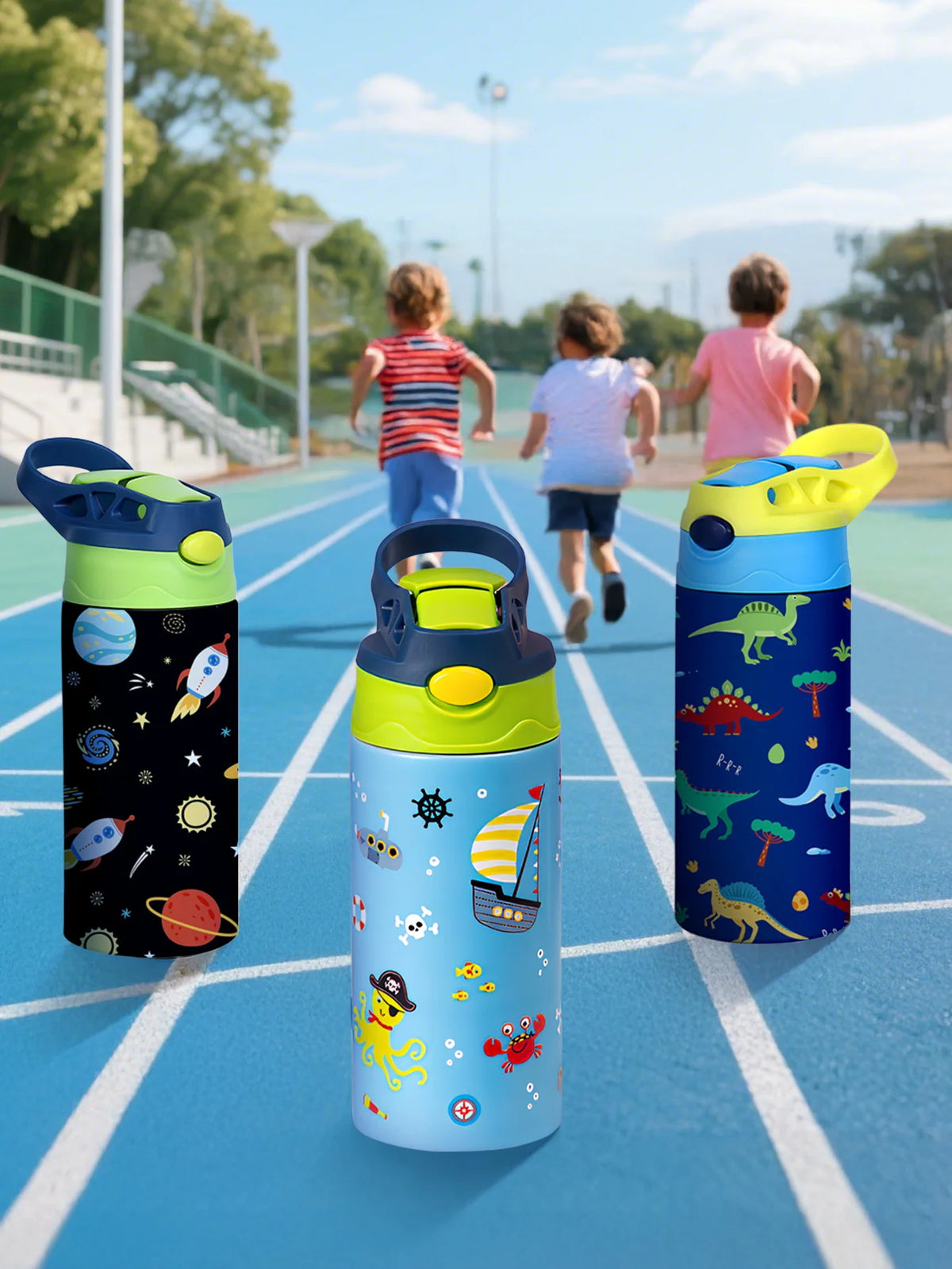 A trio of colorful insulated stainless steel thermos cups with various cartoon patterns resting on a blue running track.