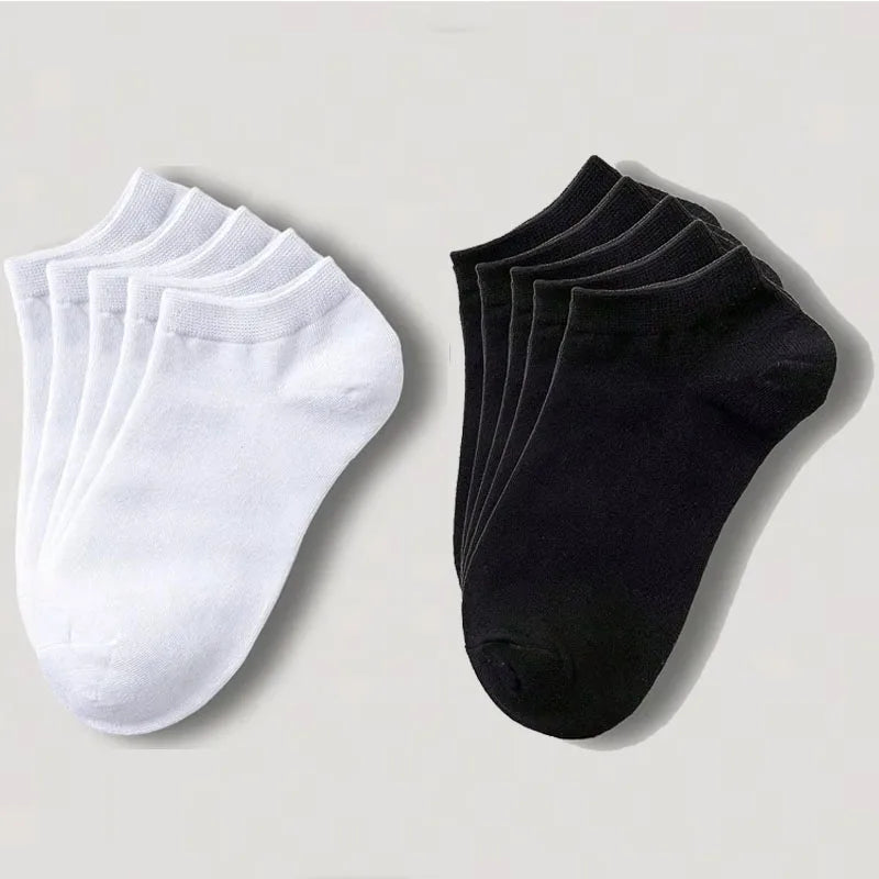 Un juego de calcetines unisex de algodón transpirable blanco y negro, colocados sobre una superficie clara.