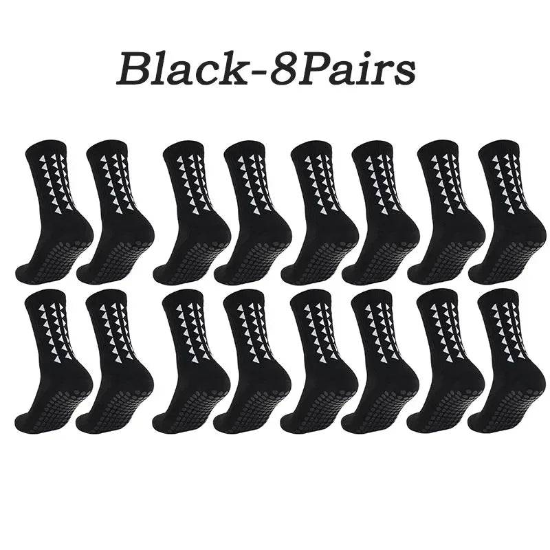 Eight pairs of black multi-sport athletic grip socks laid out in a row.