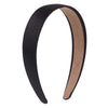 A black and nude satin hair band shown from the side.