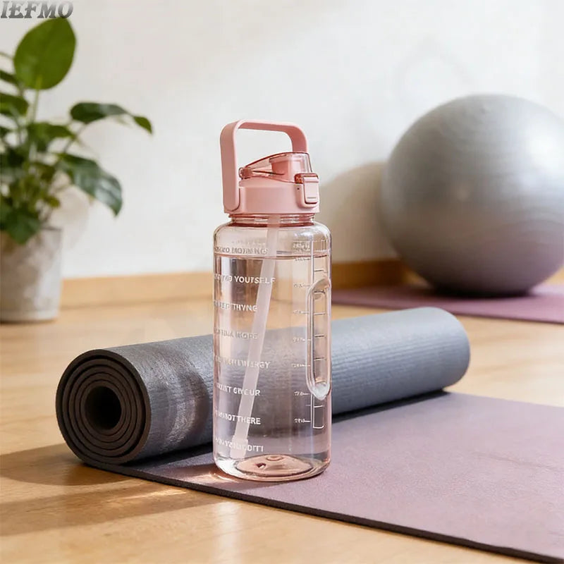 Klare rosa Wasserflasche mit Dosierverschluss und Zeitmarkierung auf einer Yogamatte neben einer gerollten grauen Matte.
