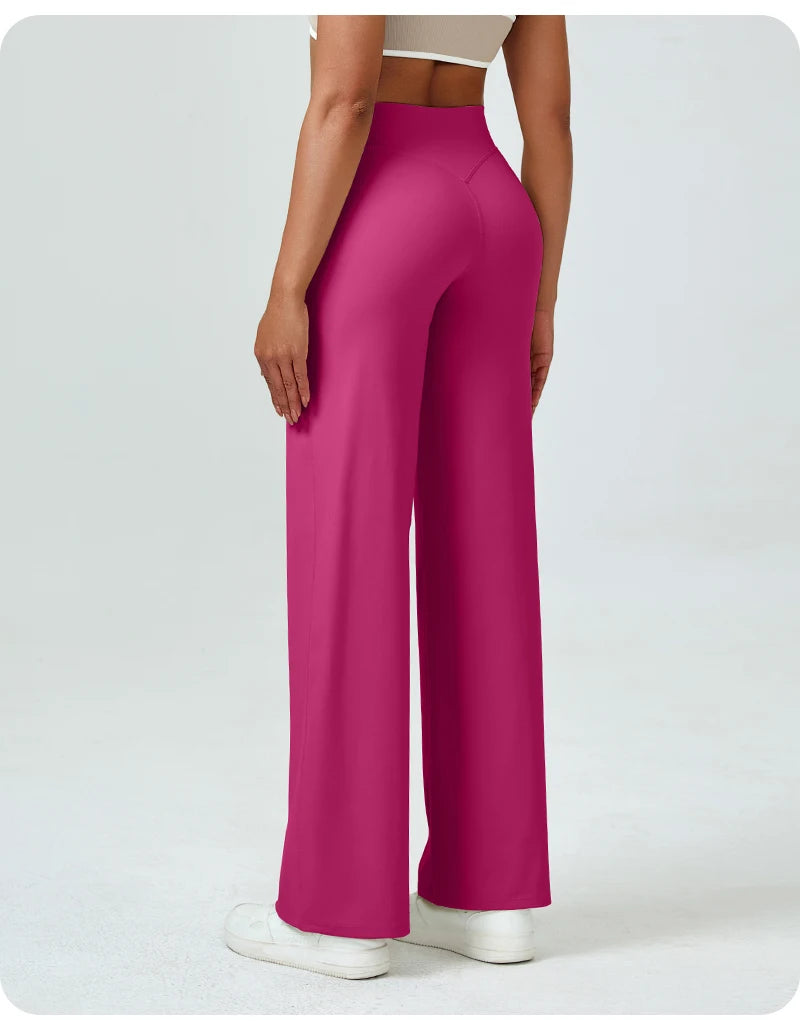 A woman is modeling high waisted magenta yoga pants with a light top.