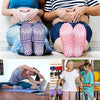 A pair of pink non-slip grip socks for yoga and pilates are shown on a person's feet.
