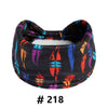 A black fabric turban headband with colorful abstract patterns
