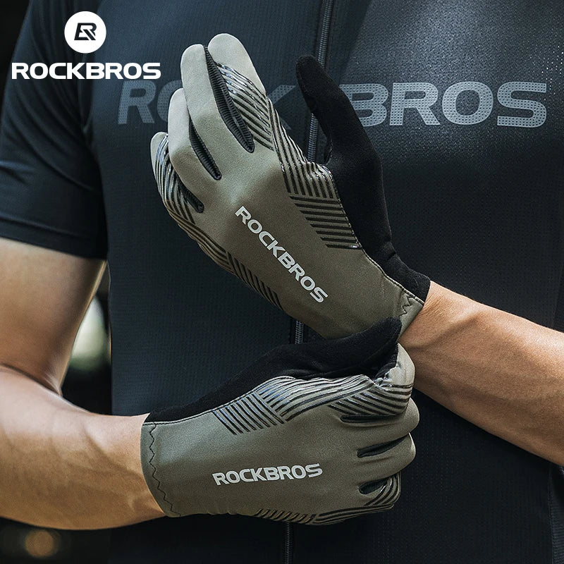 A close-up of a pair of olive green cycling performance gloves being held by a person.