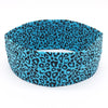 A teal and black leopard print women's sports headband worn on a white background.