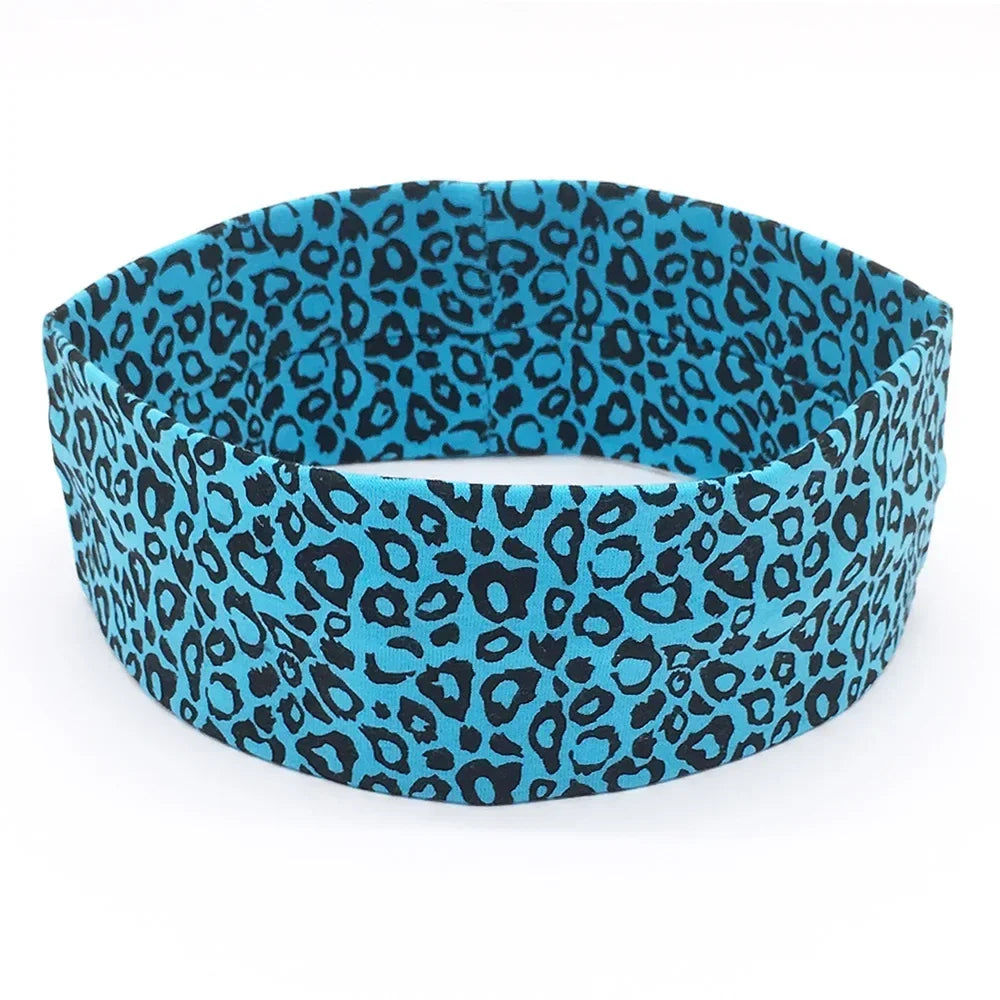 A teal and black leopard print women's sports headband worn on a white background.