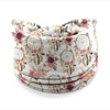 Un bandeau à cheveux large avec un motif bohème de fleurs roses et mauves sur fond clair.