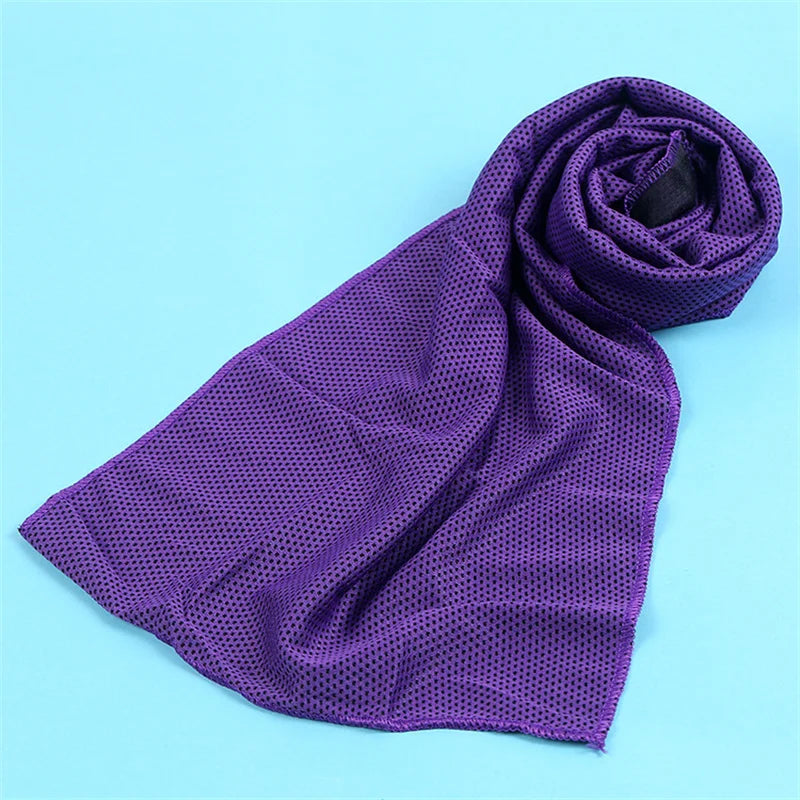 A purple microfiber cooling towel is rolled up on a light blue background.
