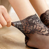 Close-up of a person wearing black lace mesh ankle socks on their foot.