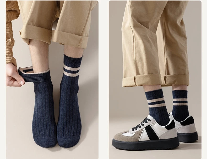 A pair of navy blue ribbed socks with light stripes worn on a person's feet.