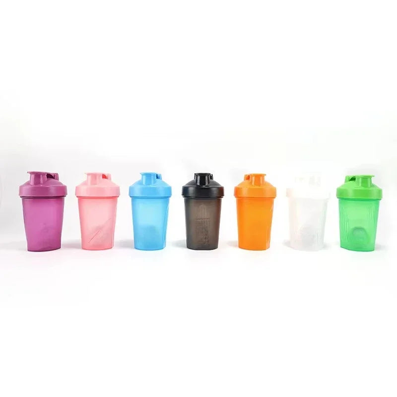 A row of eight plastic portable protein shaker bottles in various colors including purple, pink, blue, black, orange, and gre