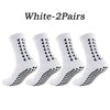 A pair of white multi-sport athletic grip socks shown flat.