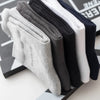 A stack of five men's bamboo fiber socks in various shades of gray, black, and white.