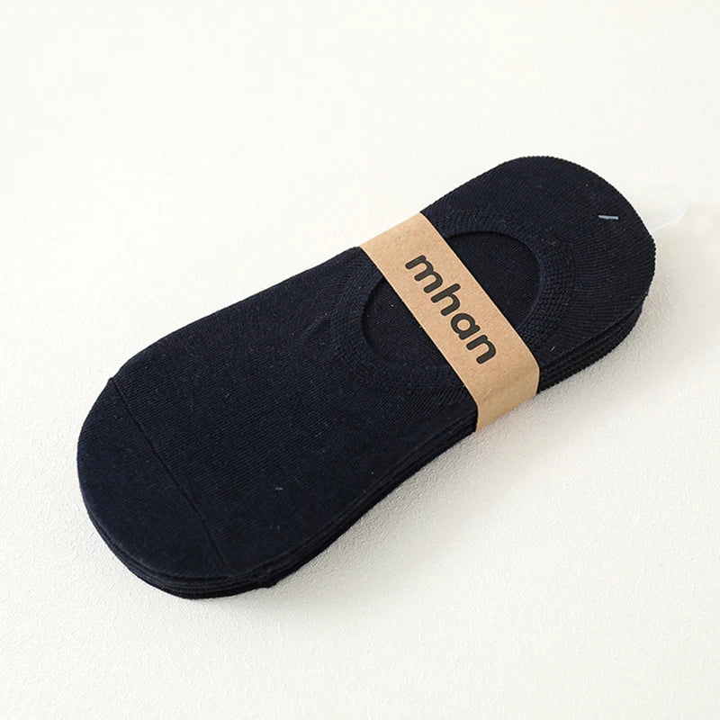 A dark navy blue ankle sock with a light brown woven label reading mhan