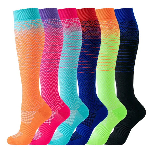 Une rangée de chaussettes de compression montantes pour femmes de diverses couleurs vives : orange, rose, bleu et vert.