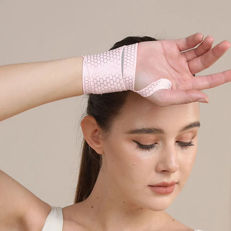 A woman is wearing a pink, ultra-thin spandex wrist guard for joint support on her hand.