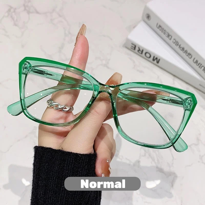 Eine Hand hält eine grüne photochromische multifokale Brille vor einem weißen Hintergrund.
