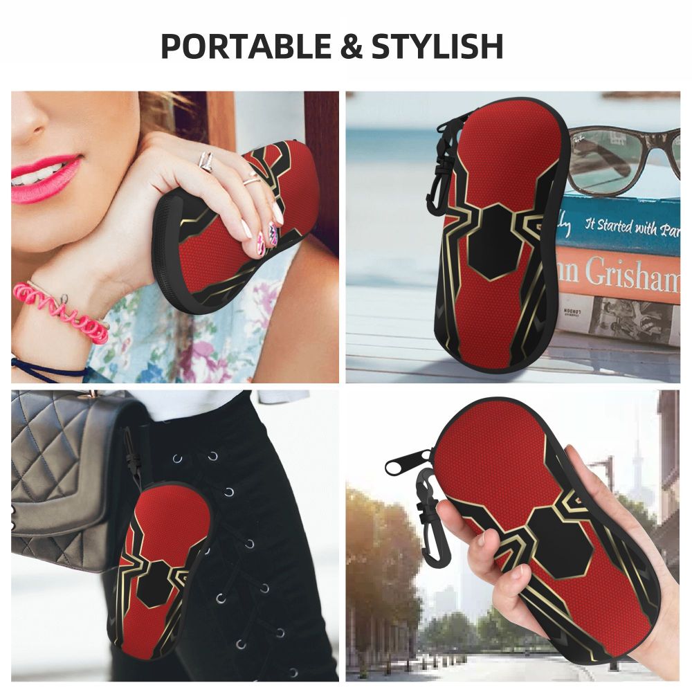 A black and red spider web patterned eyeglass pouch is shown being worn on a person's hand and attached to a black leather ga