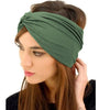 Una mujer lleva una diadema bohemia ancha de color verde oliva oscuro alrededor de su cabello.