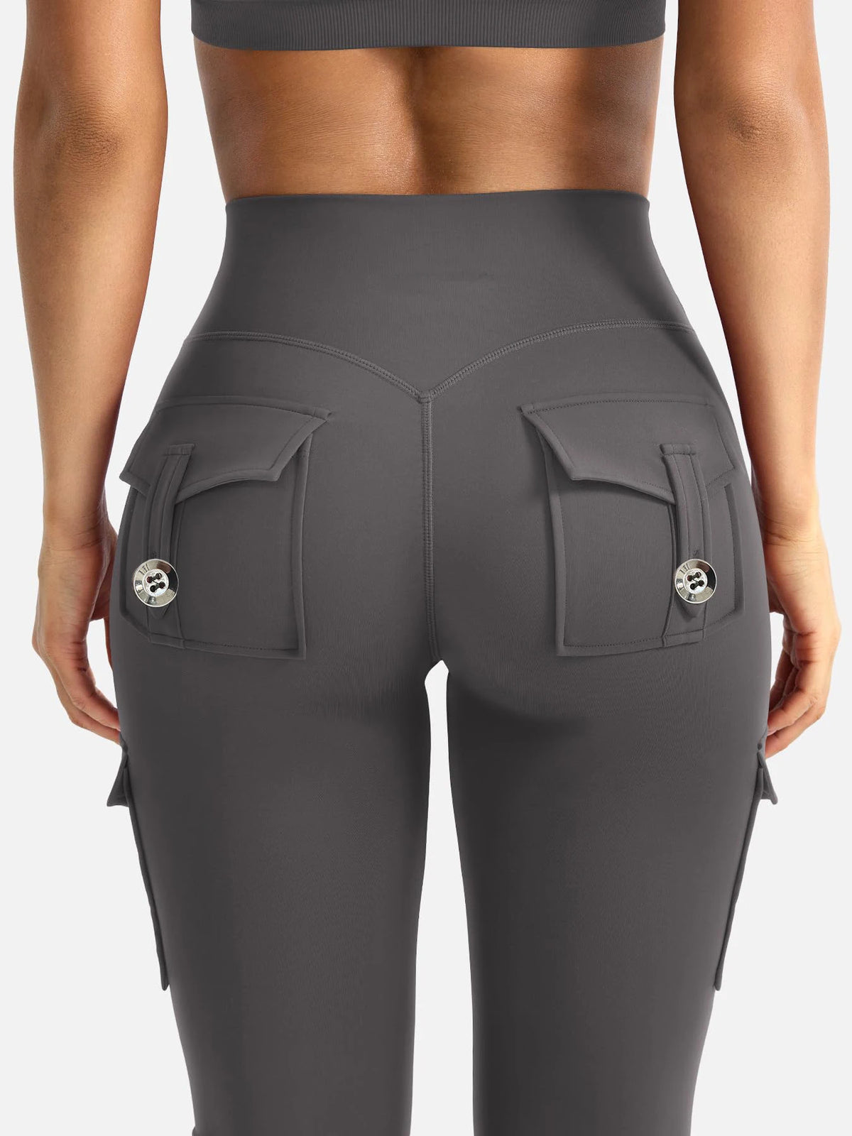 A close-up view of high-waisted gray fitness pants with multiple pockets and a ribbed top visible above.