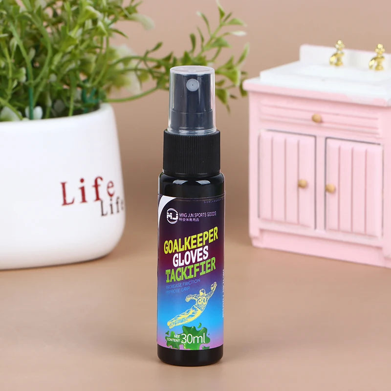 A dark bottle of Goalkeeper Gloves Tackifier spray with a black pump dispenser sits in front of a pink cabinet.