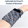 A close-up of a black and white striped, lightweight fabric wrist bag with a zipper on a person's arm.
