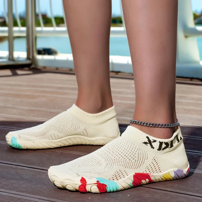 A pair of beige waterproof quick-dry outdoor hiking shoes resting on a wooden deck.